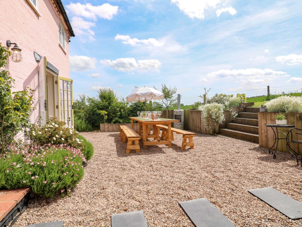 A garden with a picnic table and chairs at Gapstile in Abbots Bromley
