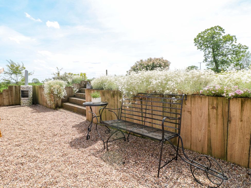 A garden area with a bench and table at Gapstile in Abbots Bromley