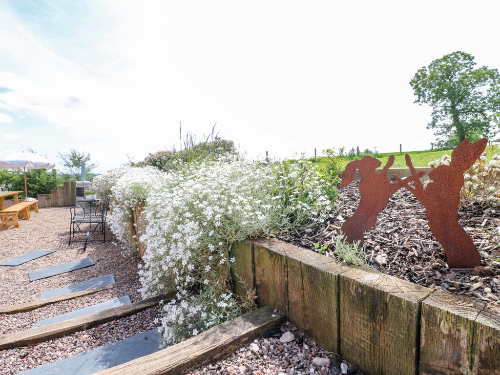 A garden with flowers and sculptures at Gapstile in Abbots Bromley