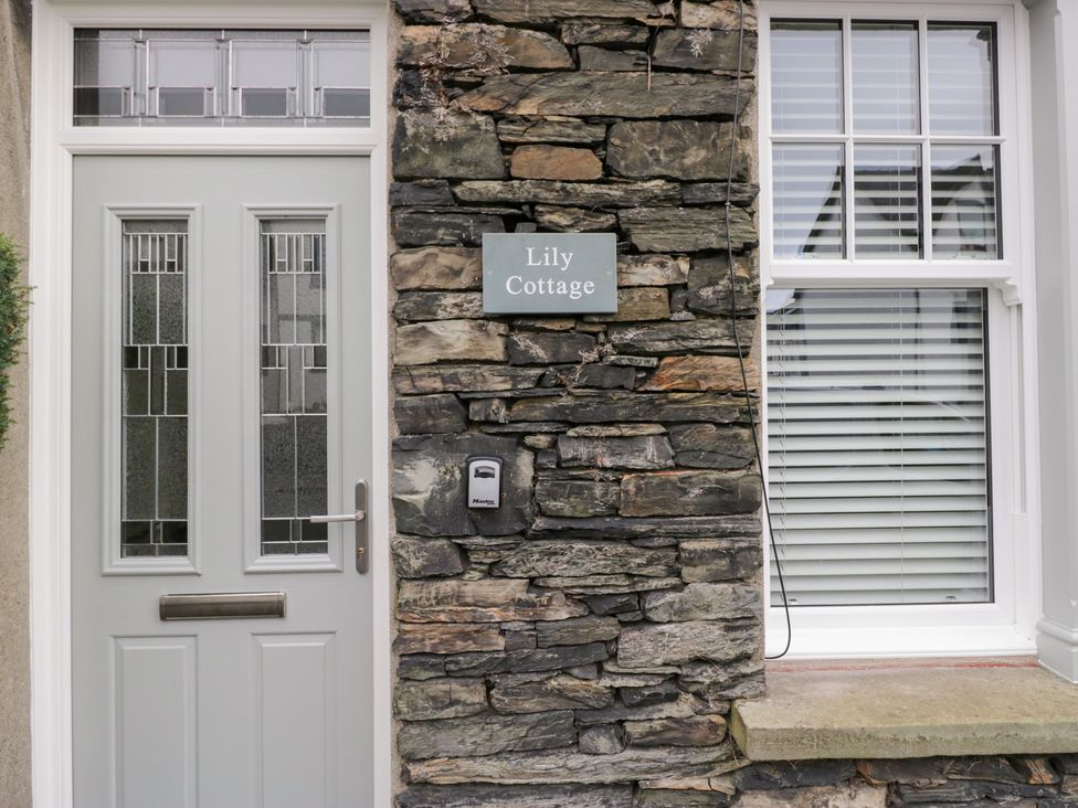 An entrance with a door and stone wall at Lily Cottage in Windermere