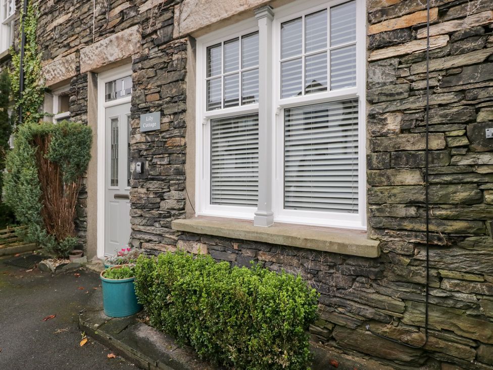 A stone wall with a door and windows at Lily Cottage in Windermere
