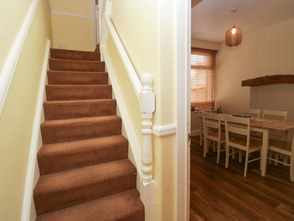 Stairs leading to a dining area with a table and chairs at 28 Rock Villas Carnforth