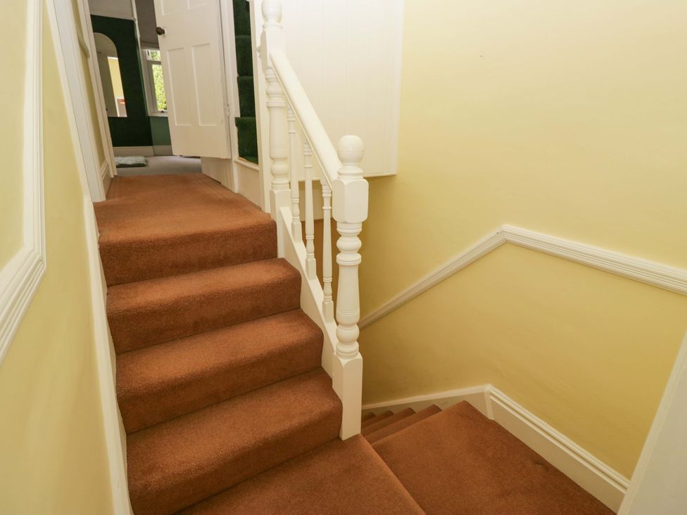A staircase with a carpet and handrail at 28 Rock Villas in Carnforth