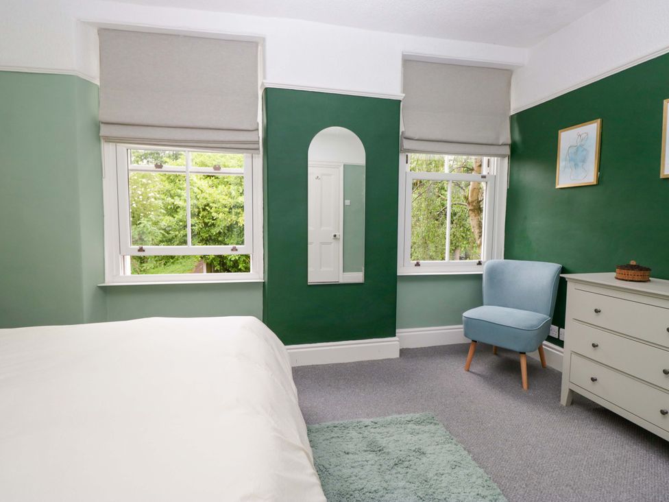 A bedroom featuring a bed, chair, and window at 28 Rock Villas Carnforth