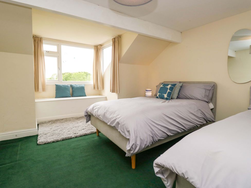 A bedroom with two beds and a window seat at 28 Rock Villas in Carnforth