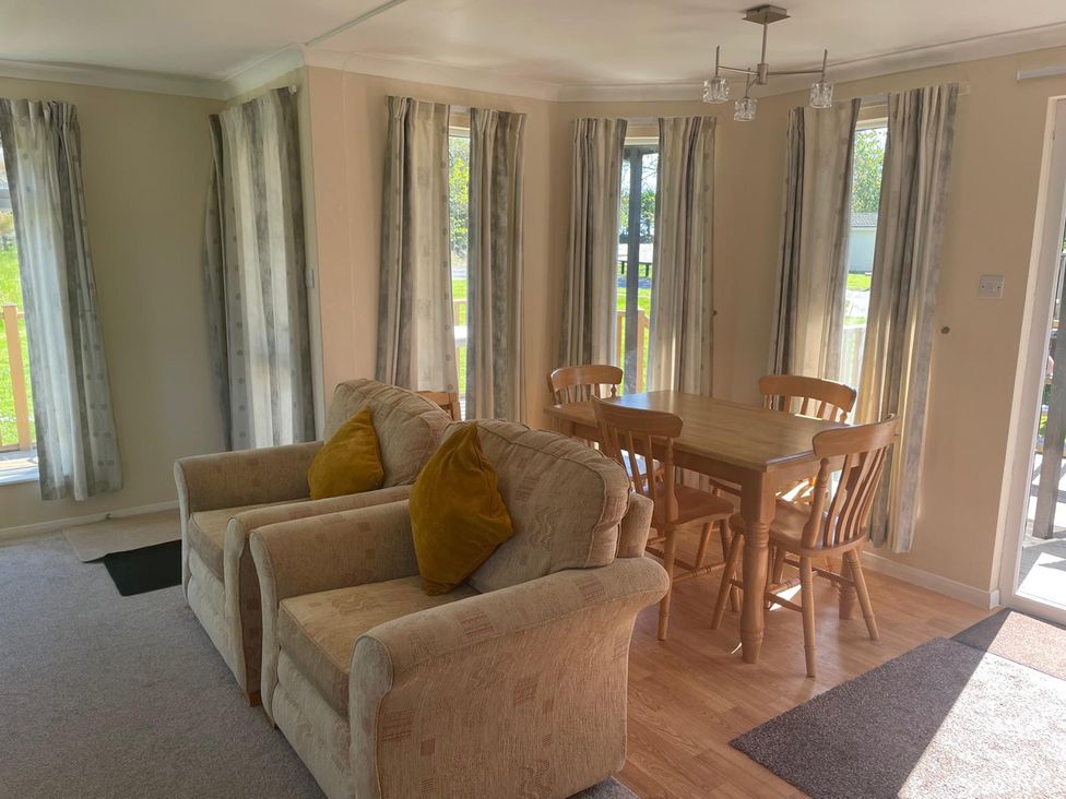 A dining room with a table and chairs at Kastel in Tregolds near St Merryn