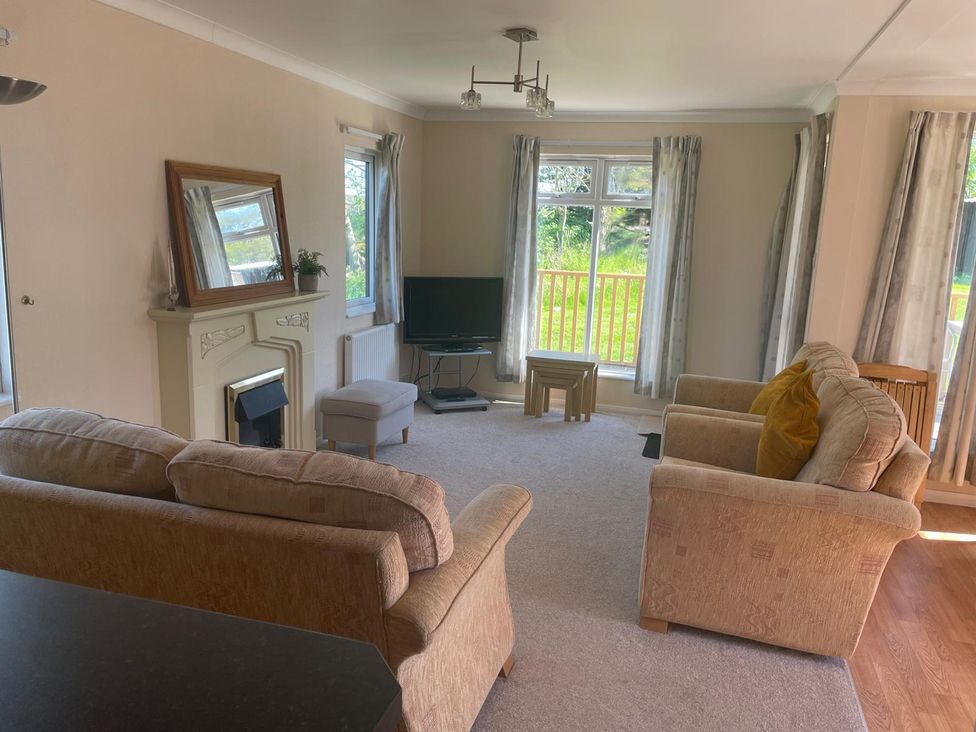 A living room with a sofa and television at Kastel Tregolds near St Merryn
