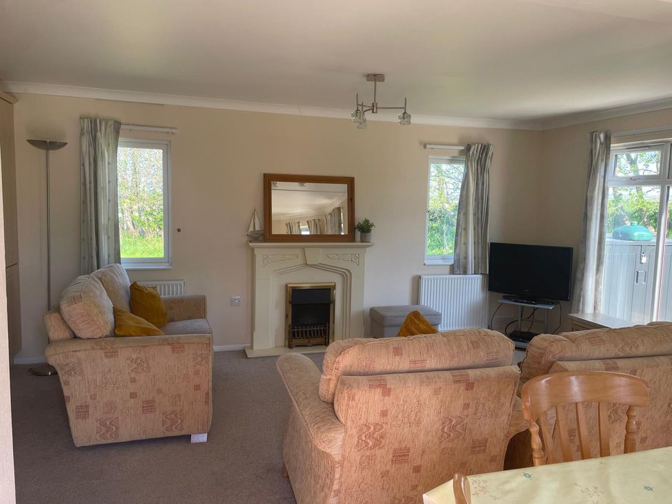 A living room with a sofa and television at Kastel in Tregolds near St Merryn