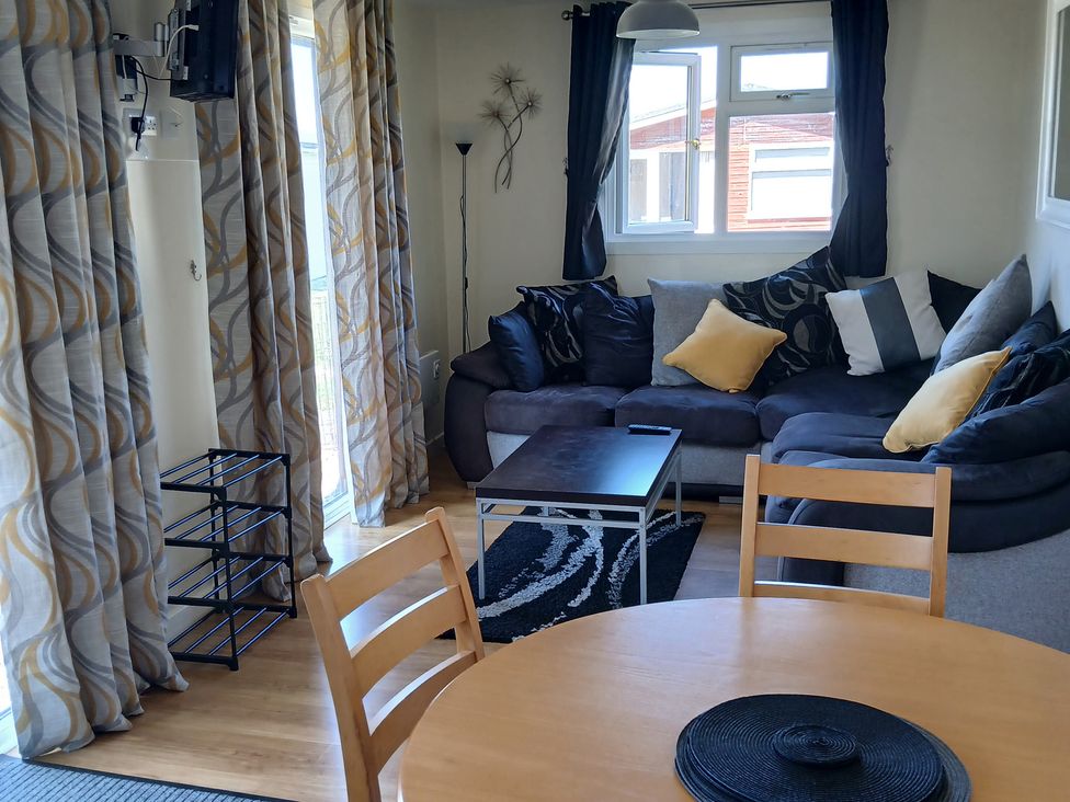 A living room with a sofa and coffee table at Gwanda in Tregolds near St Merryn