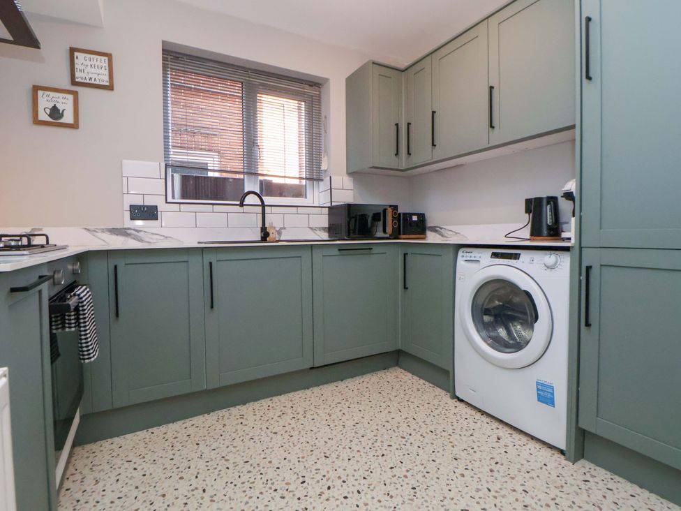 A kitchen with a washing machine and microwave at The Cloud House @ Hoole in Chester
