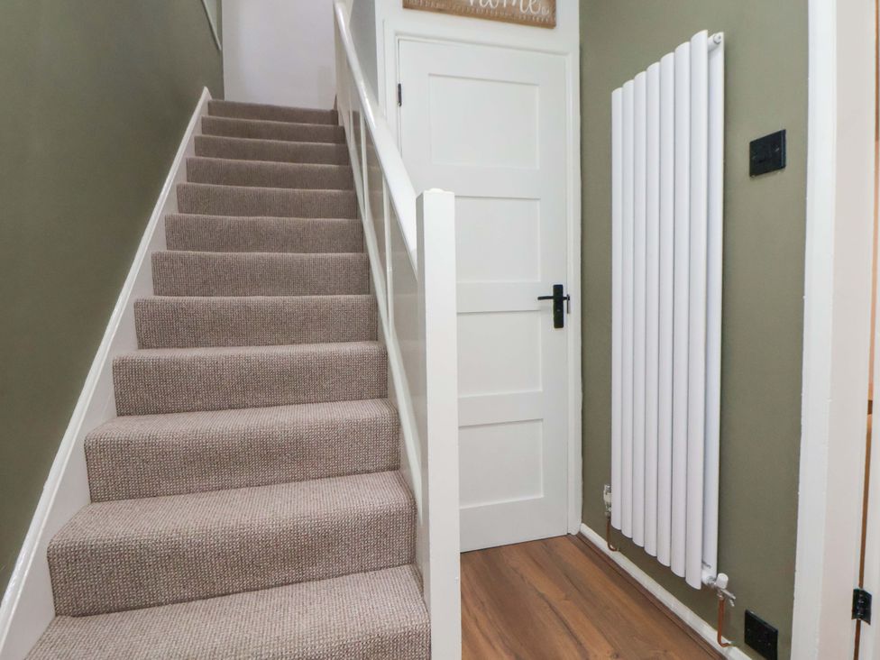 A hallway with stairs, a door, and a radiator at The Cloud House @ Hoole in Chester