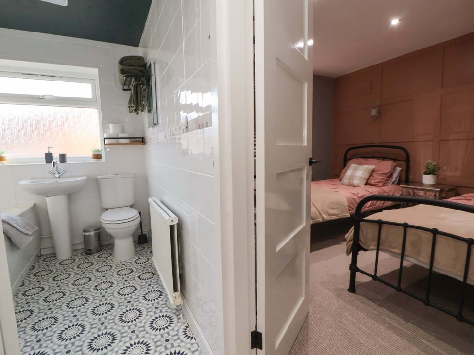 A bathroom with a shower and a bedroom with two beds at The Cloud House @ Hoole in Chester