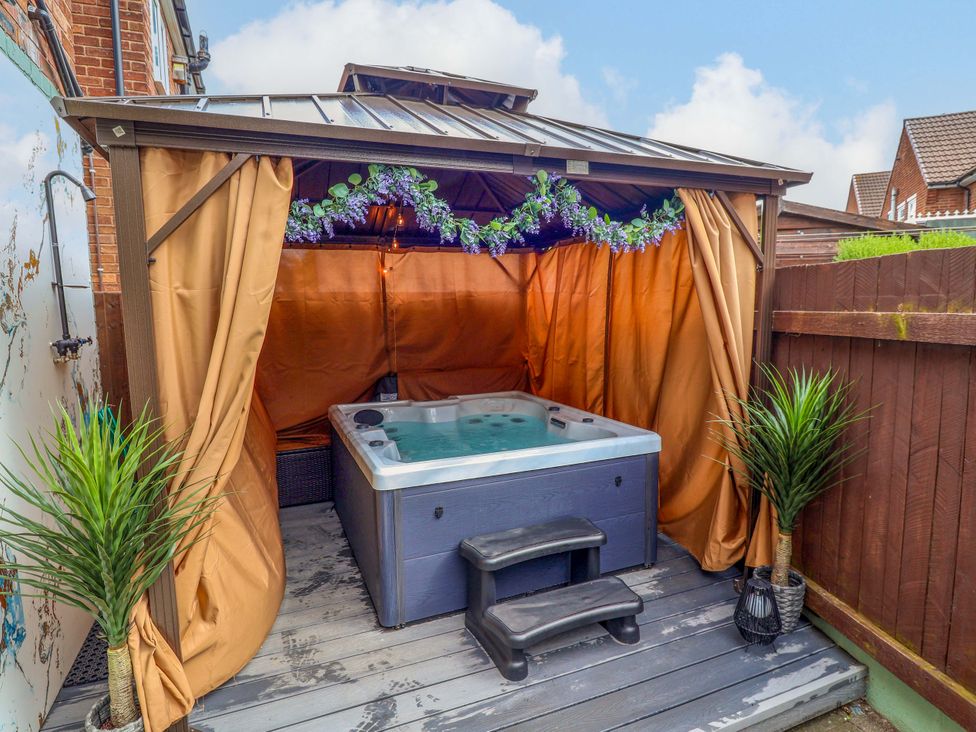 An outdoor hot tub with canopy and plants at Steam and Stay @ Hoole in Chester