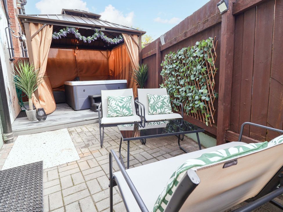 A garden area with a hot tub and seating at Steam and Stay @ Hoole in Chester