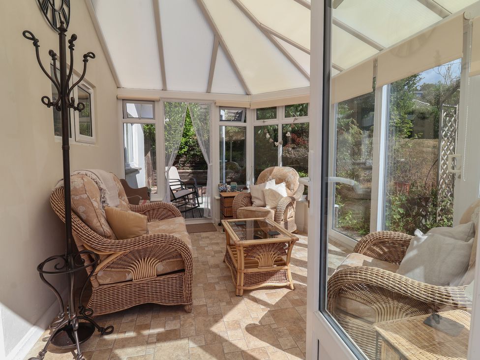A conservatory with wicker furniture at Little Willesleigh Goodleigh near Barnstaple
