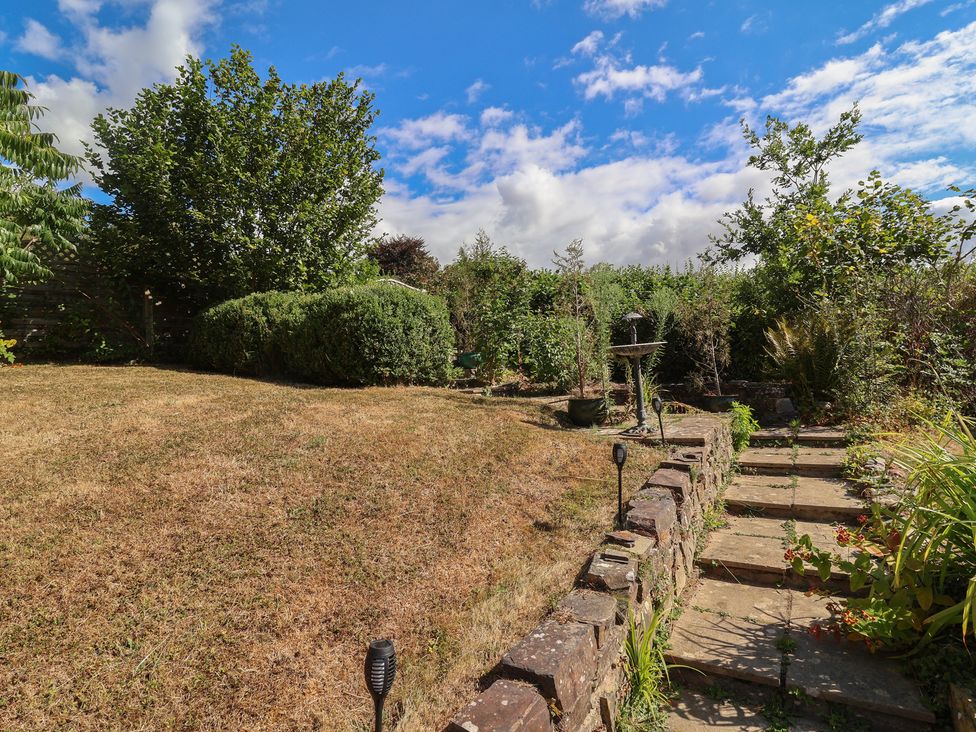 A garden with steps leading up to bushes and trees at Little Willesleigh Goodleigh near Barnstaple