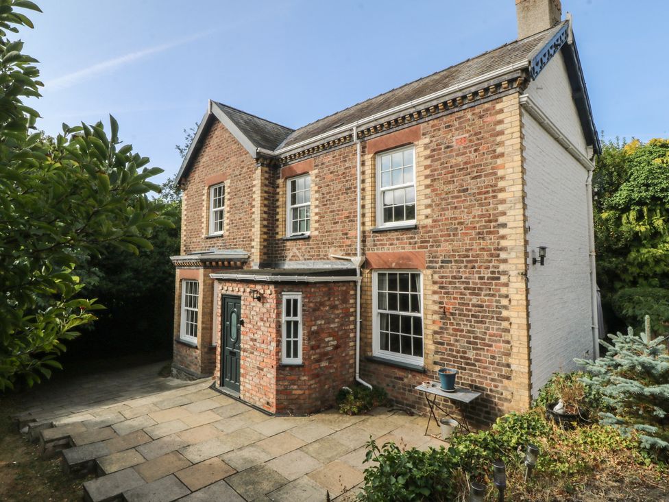 A brick house with a door and windows in an outdoor area at Gweryl Lodge in Conwy