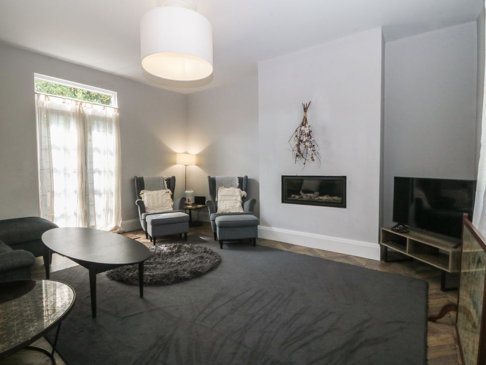 A living room with furniture and a television at Gweryl Lodge in Conwy