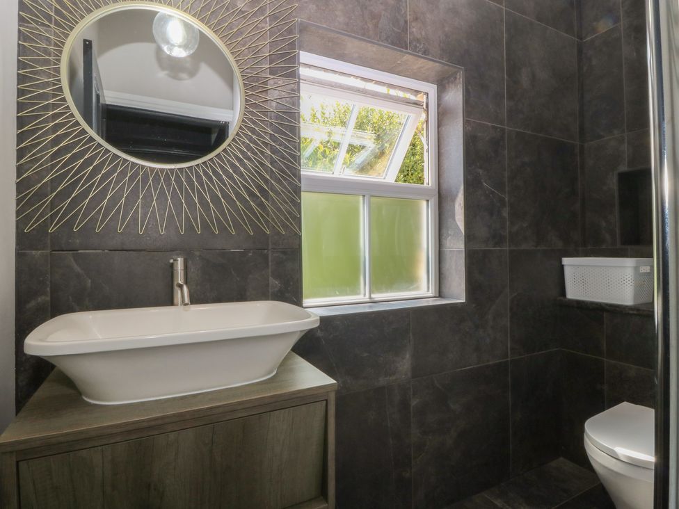 A bathroom with a sink and mirror at Gweryl Lodge in Conwy