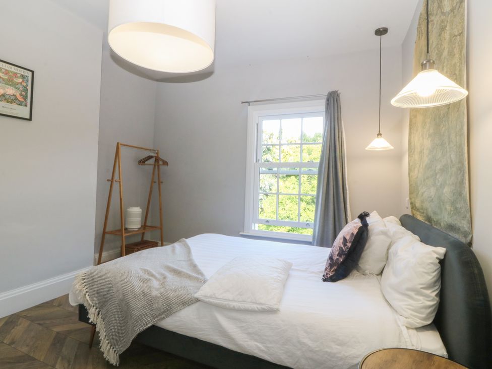 A bedroom with a bed and window at Gweryl Lodge in Conwy