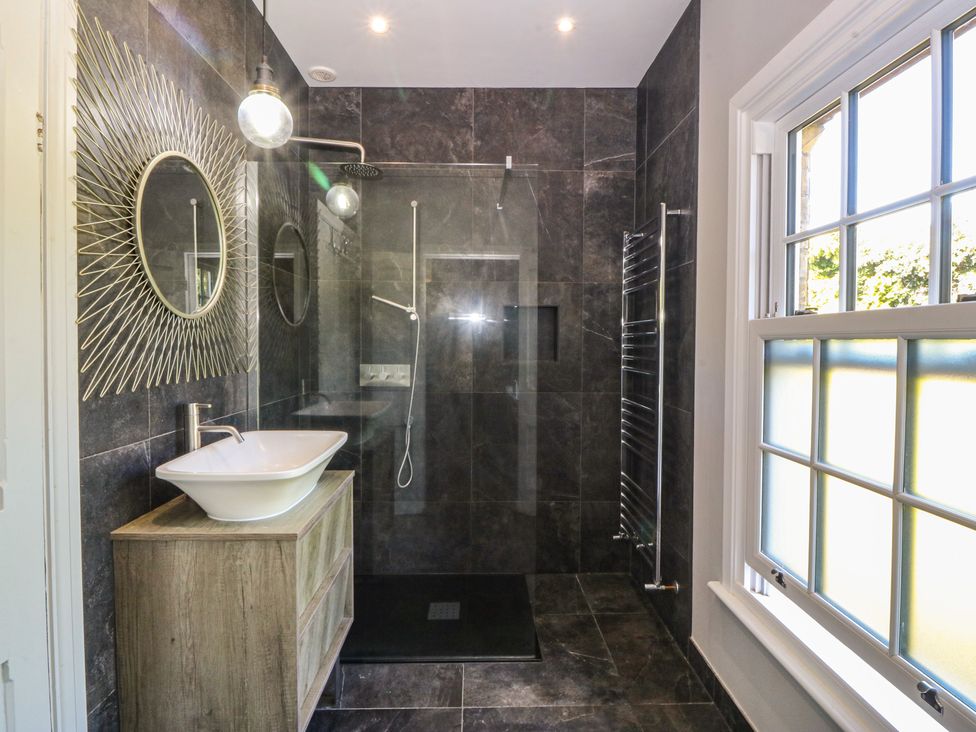 A bathroom with a shower and sink at Gweryl Lodge in Conwy
