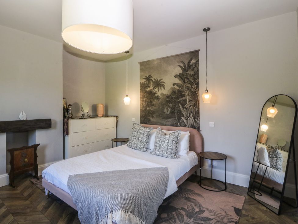 A bedroom with a bed and dresser at Gweryl Lodge in Conwy
