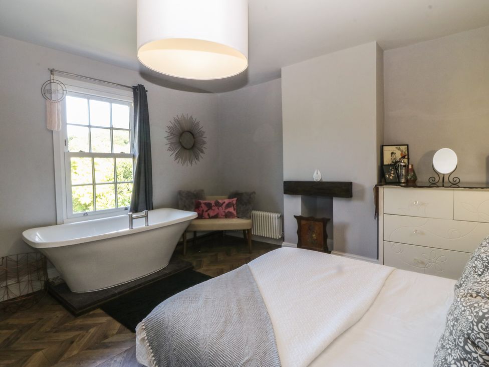 A bathroom with a bathtub and a window at Gweryl Lodge Conwy