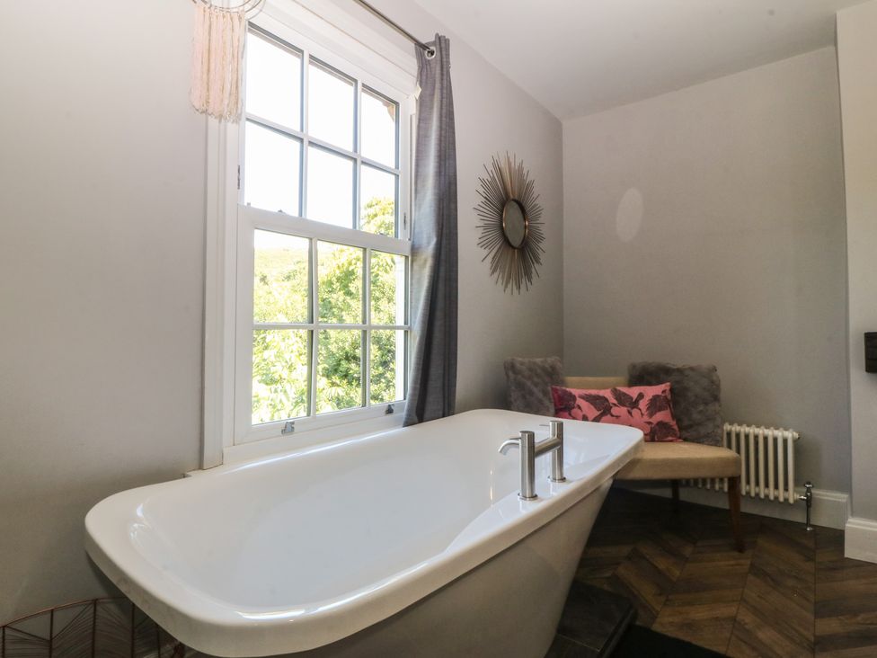A bathroom with a bathtub and a window at Gweryl Lodge in Conwy