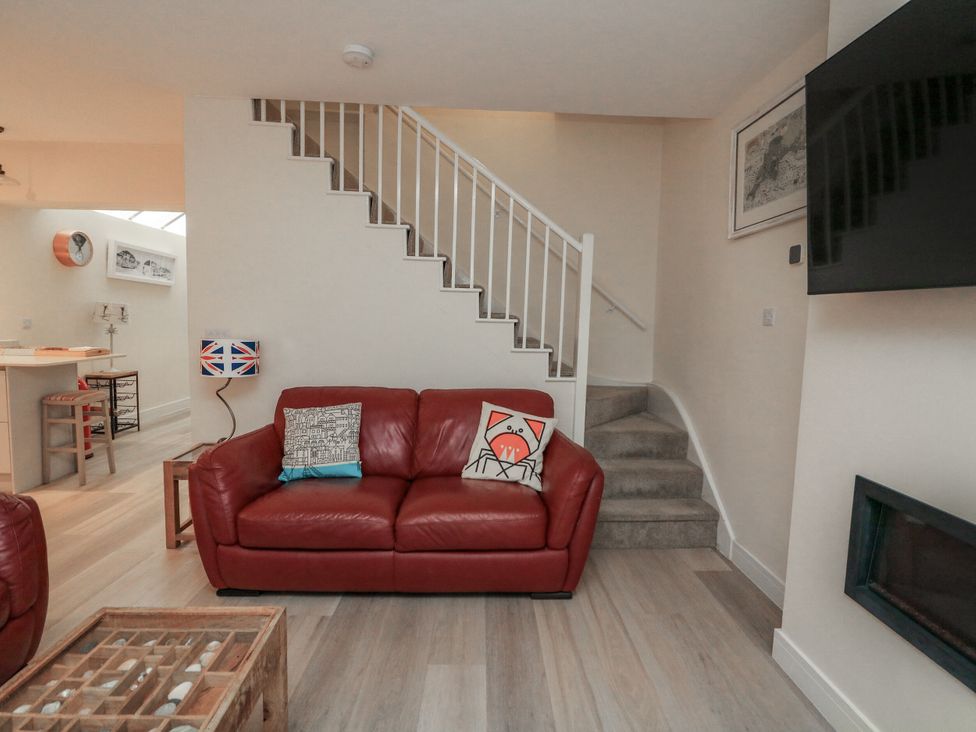 A living room with a sofa and stairs at Full Deck in Dartmouth