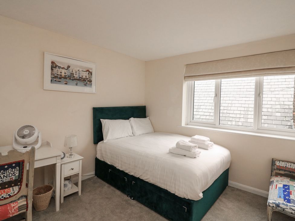A bedroom with a bed, chair and fan at Full Deck in Dartmouth