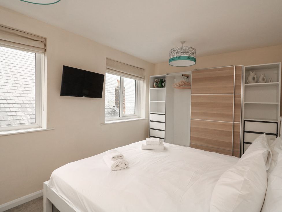 A bedroom with a bed, television, and wardrobe at Full Deck in Dartmouth