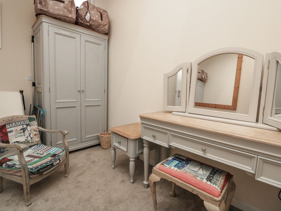 A dressing room with a wardrobe and dressing table at Full Deck in Dartmouth