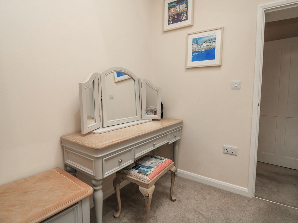 A vanity table with a mirror in a bedroom at Full Deck Dartmouth