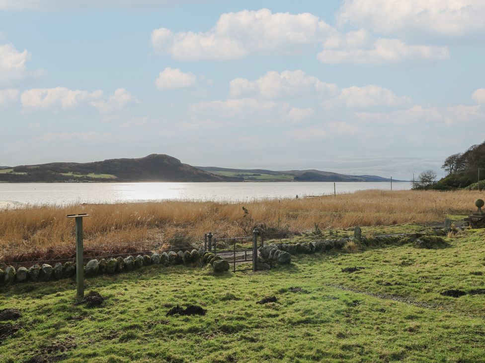 A view of a lake with grass and a hill at South Lodge in Ardpatrick near Tarbert