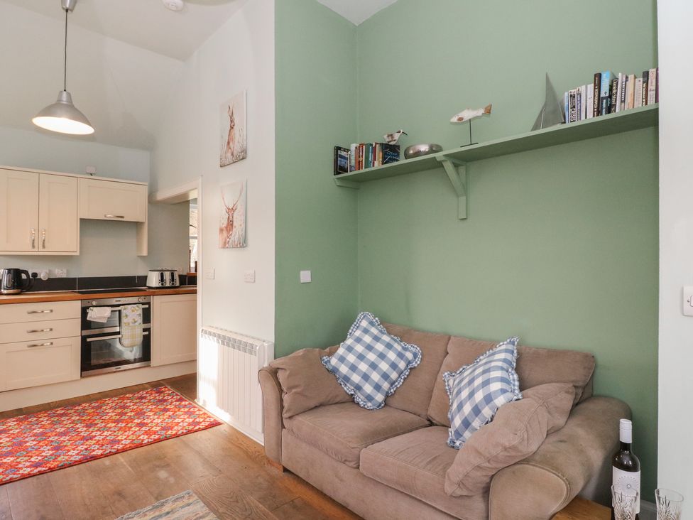 A living room with a sofa and open kitchen at South Lodge in Ardpatrick near Tarbert