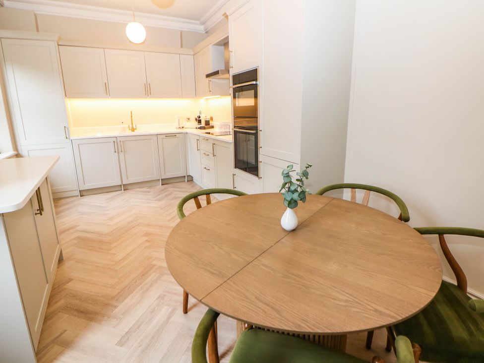 A kitchen with a dining table and four chairs at Pavilion Suite in Buxton