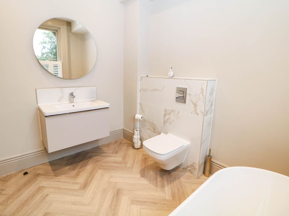 A bathroom with a toilet and washbasin at Pavilion Suite in Buxton