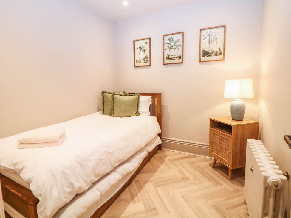 A bedroom with a single bed and a nightstand at Pavilion Suite Buxton