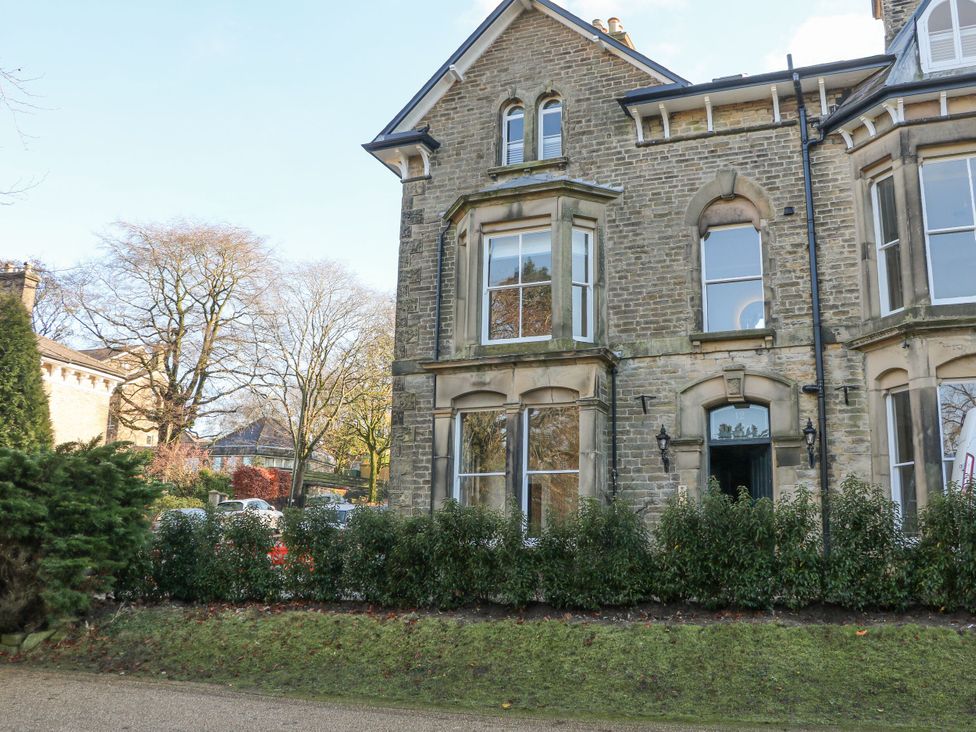 An exterior view of a stone building with windows and door at Pavilion Suite, Buxton