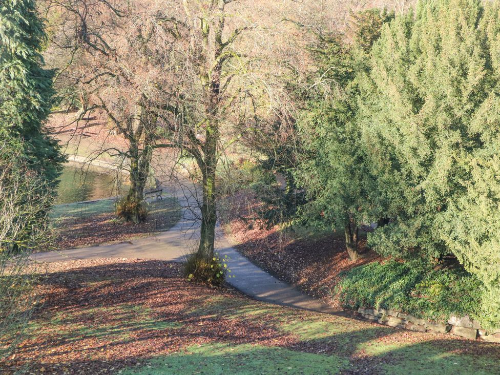 A park with a path and trees near water in Pavilion Suite Buxton