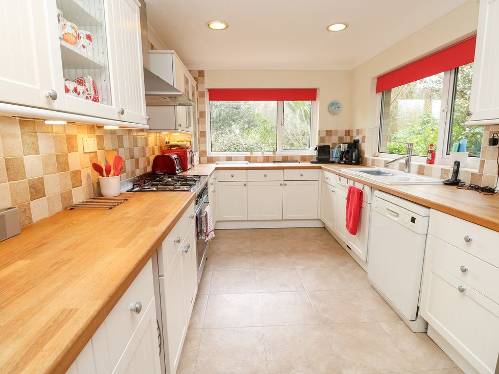 A kitchen with cabinets and cooking appliances at Tall Timbers in Ventnor