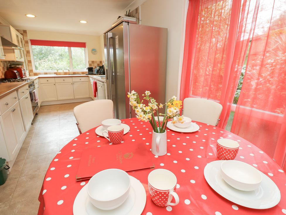 A kitchen with a table set for dining at Tall Timbers in Ventnor