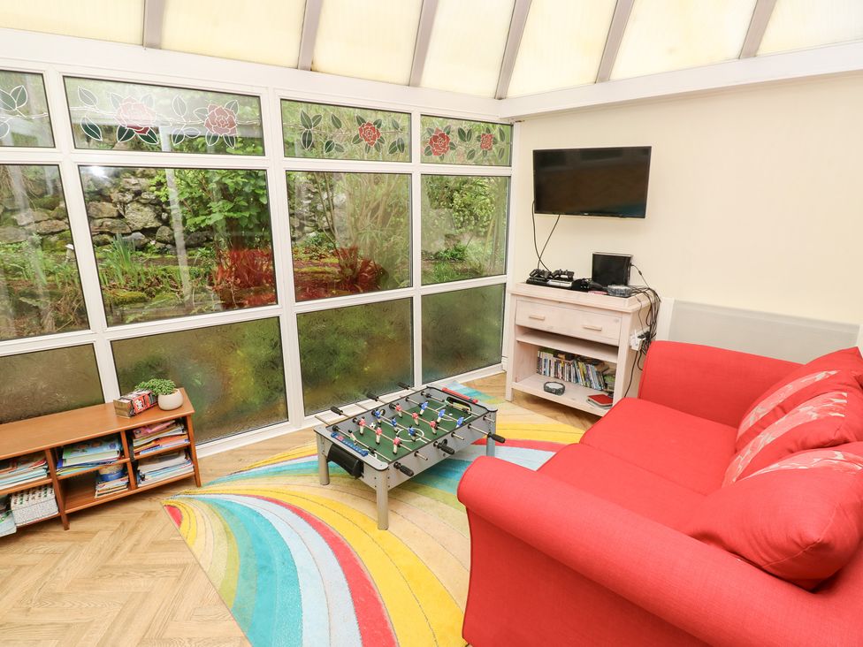 A conservatory with a TV and foosball table at Tall Timbers in Ventnor