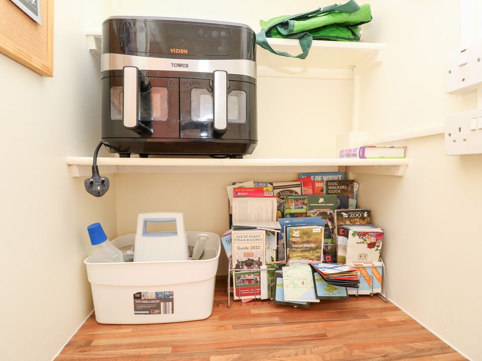 A utility room with an air fryer and brochures at Tall Timbers in Ventnor