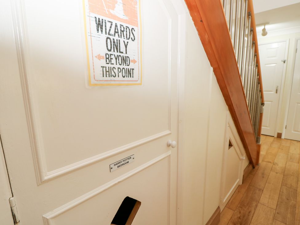 A hallway with a door marked 'Wizards Only' and a staircase at Tall Timbers in Ventnor