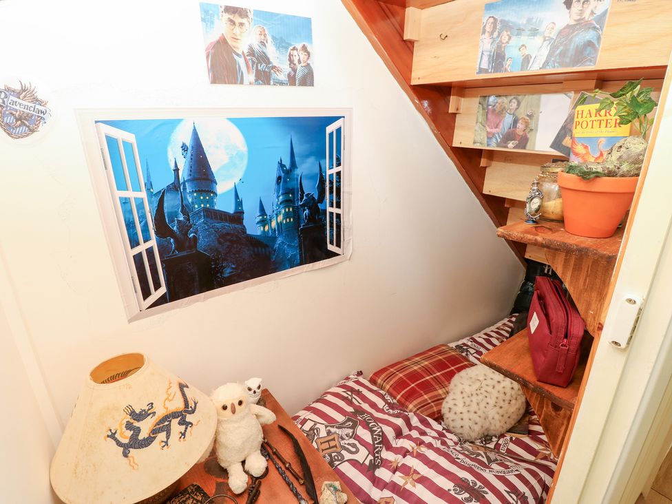 A bedroom with a bed and shelves at Tall Timbers in Ventnor