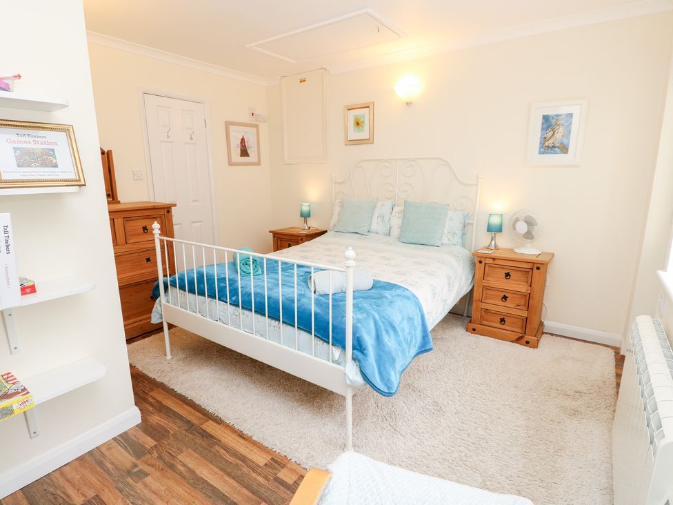 A bedroom with a bed and furniture at Tall Timbers in Ventnor