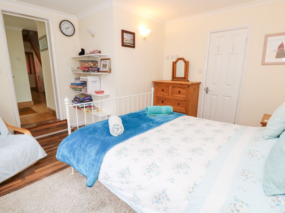 A bedroom with a bed, a drawer, and a shelf at Tall Timbers in Ventnor