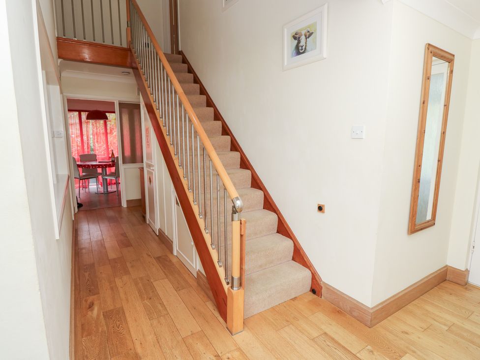 A hallway with a staircase and doorway at Tall Timbers in Ventnor