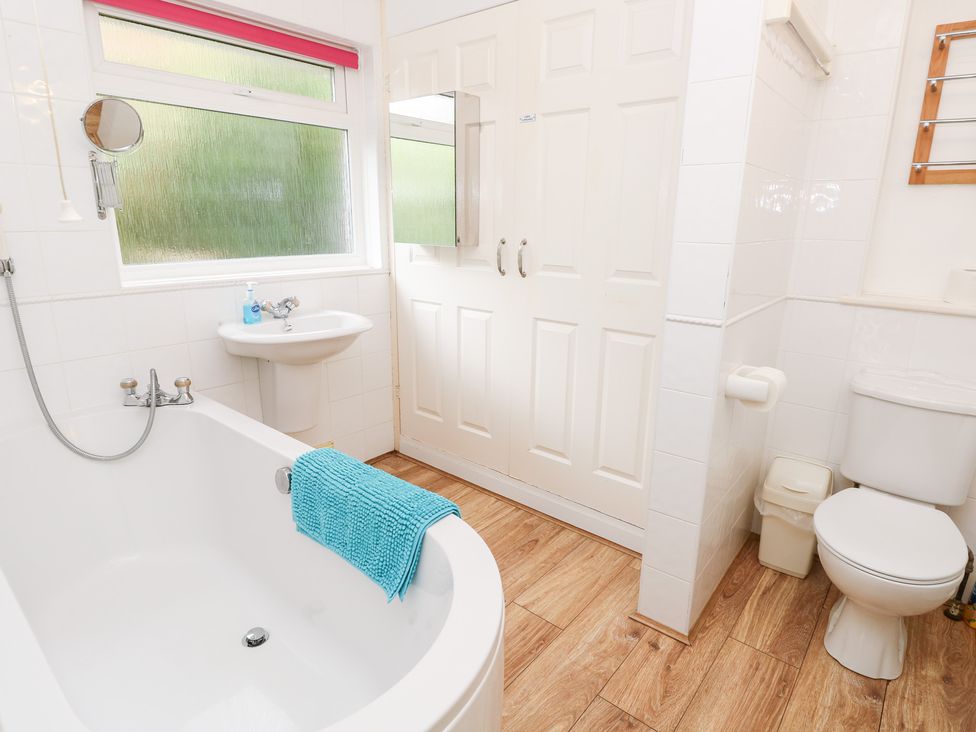 A bathroom with a bathtub, sink, and toilet at Tall Timbers in Ventnor